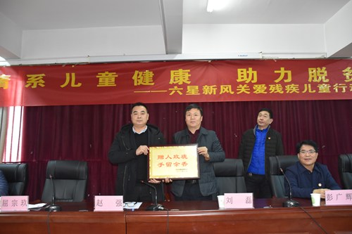 图为市政府副秘书长刘磊向爱心企业颁发荣誉牌
